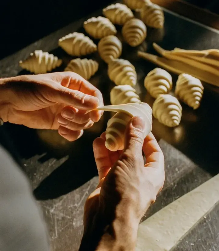Croissant dough being shaped by hand