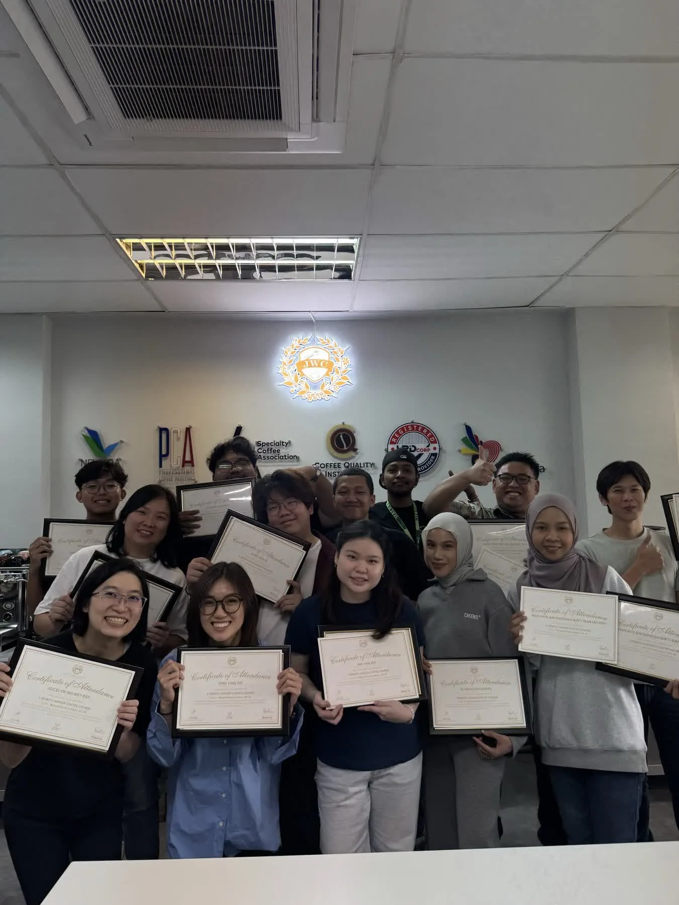 JWC Academy coffee course graduates holding certificates with instructors