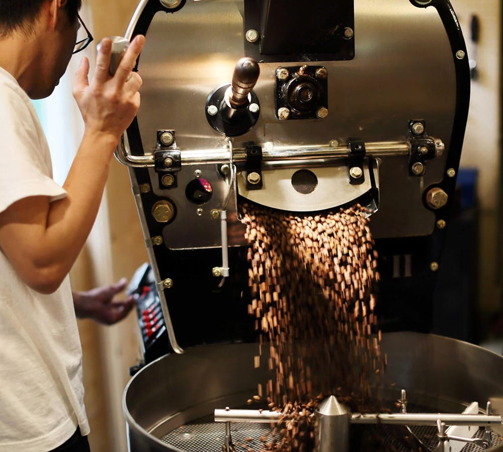 Coffee beans leaving a roasting machine